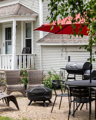 Charming cottage exterior with teal shutters and flower gardens
